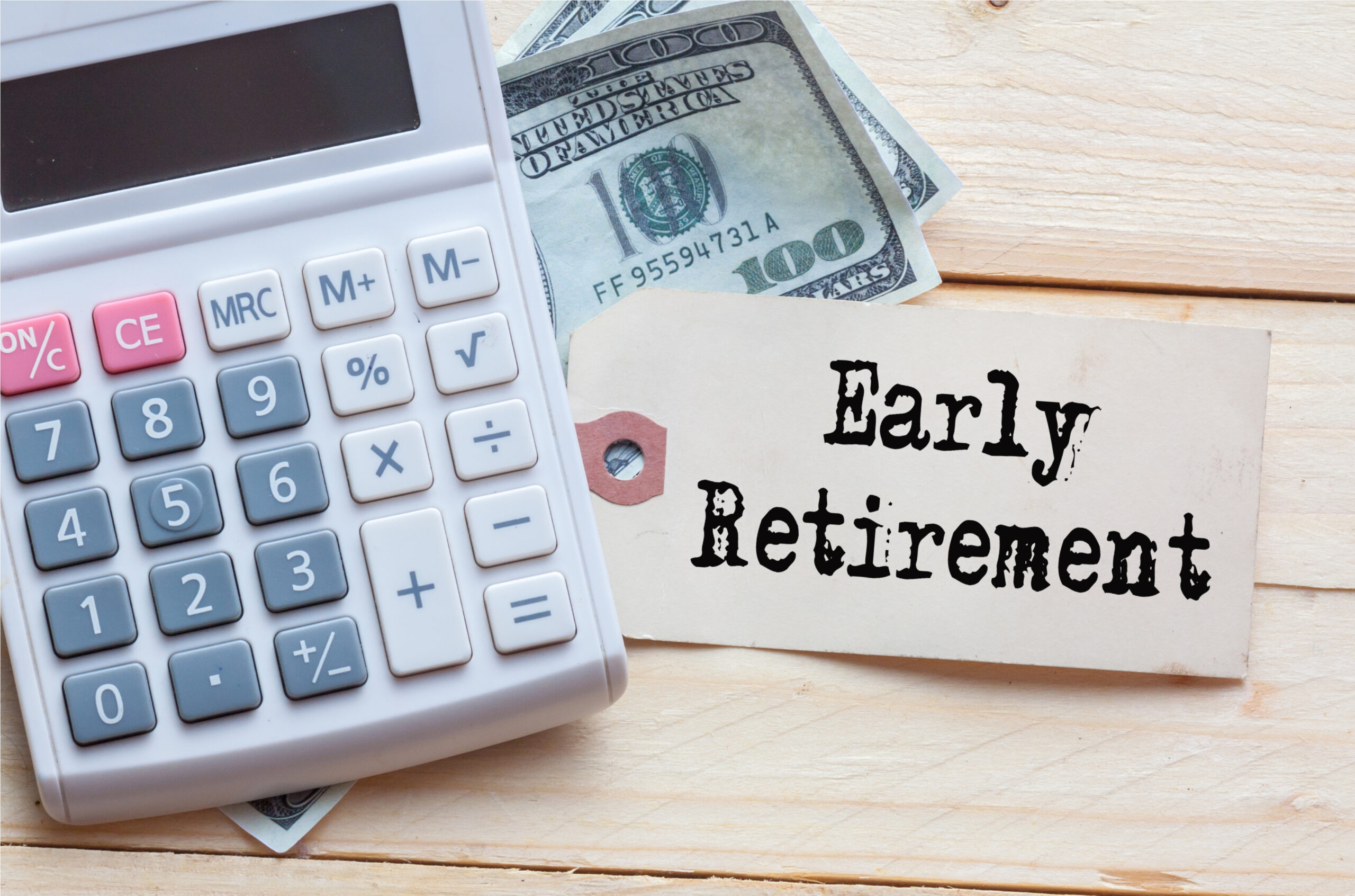 Calculator with hundred dollar bills and an early retirement tag