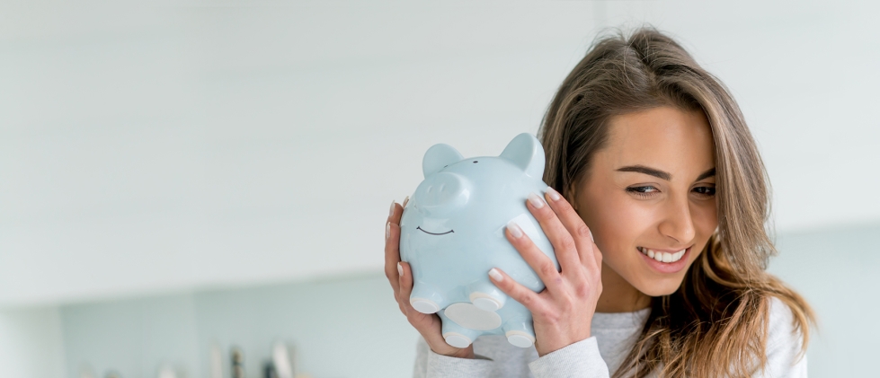 Women holding and shaking a piggy bank