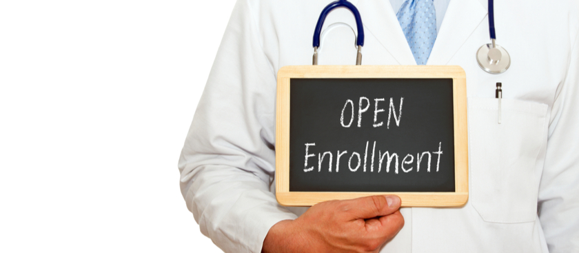 Doctor holding a board that says open enrollment