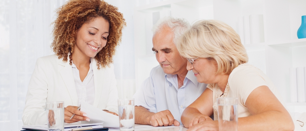 Senior couple meeting with an advisor looking over paperwork