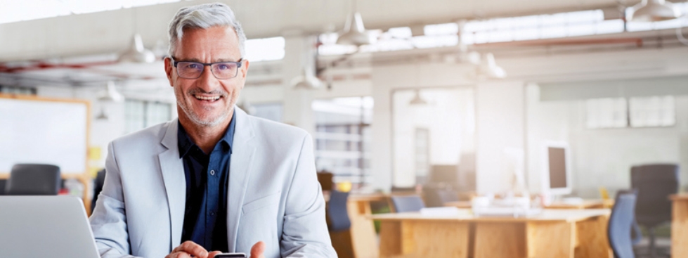 Senior man smiling and sitting in office