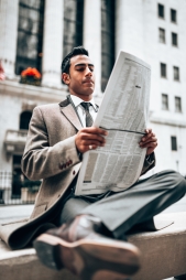 Man reading newspaper outside