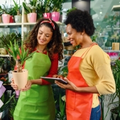 Two employees helping each other out in a flower shop